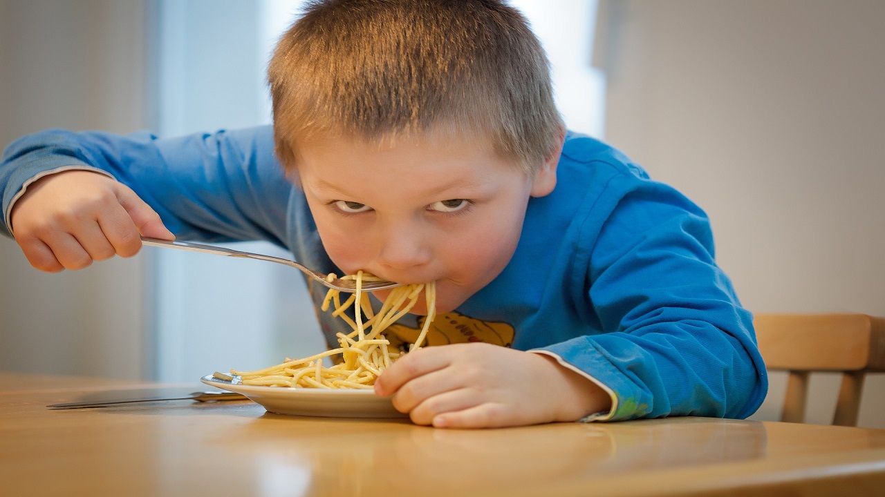 Bambino mangia spaghetti corti